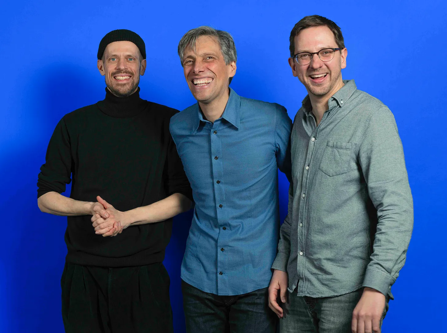 Three men from the CarbonStack team — dressed casually and smiling — stand together against a bright blue background. Their startup helps companies measure and reduce supply chain emissions.